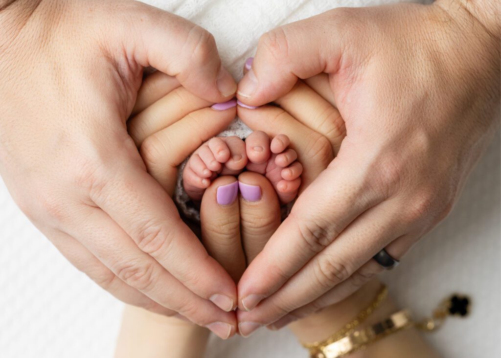 Baby close up, macro shot of hands and feet making a heart shape